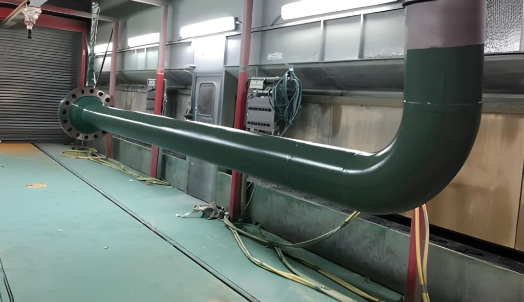 Green coated pipe section undergoing anti-corrosion treatment at LJF Custom Coatings facility in Ellon, Scotland
