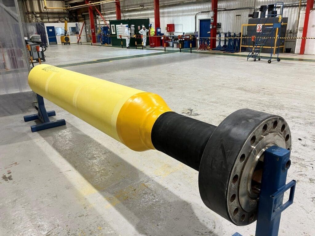 Pipeline section with yellow PU insulation, black rubber coating, and flanged end at LJF Custom Coatings' facility