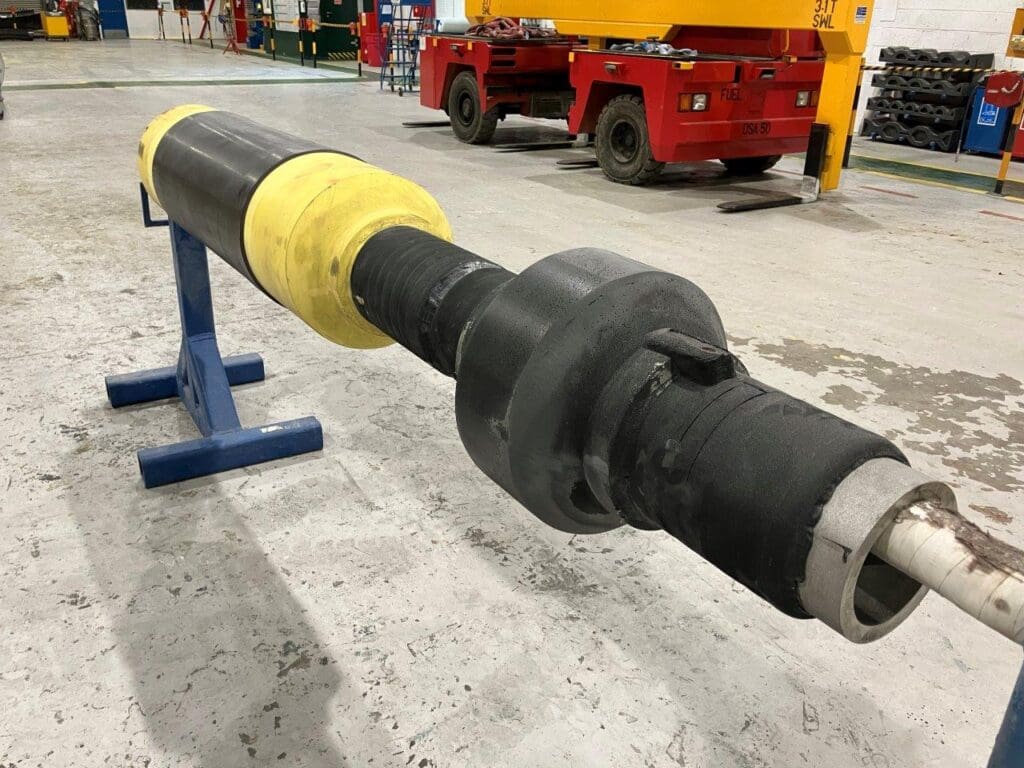 Pipeline transition joint with yellow PU insulation and black rubber outer coating at LJF Custom Coatings facility